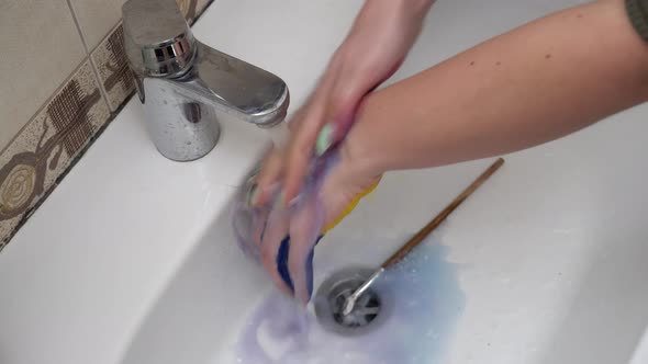 Girl Washes Off the Flag of Russia From Her Hand As a Protest Against the War alt