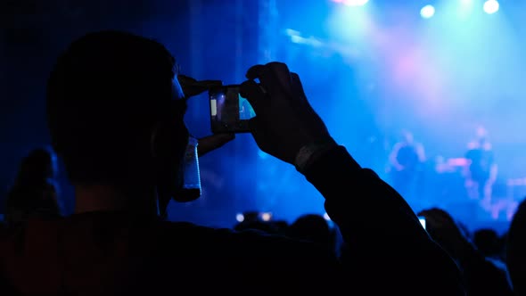 People Filming Rock Concert on Smartphones Silhouettes Crowd of Fans Dancing alt
