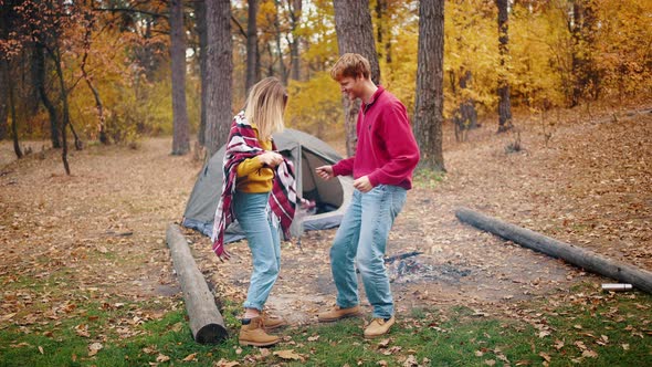 Young Couple Laughing and Dancing Having Fun in Autumn Forest alt