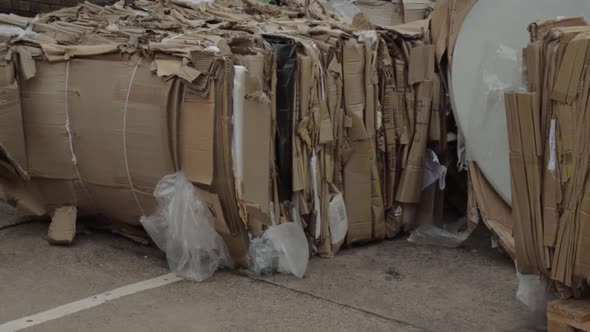 Cardboard waste wide stacked in bales wide panning shot alt
