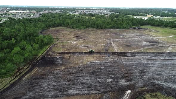 An aerial flyover of a residential site in land development phase to be built as a suburban single f alt