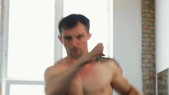 Handsome Muscular Mma Fighter Shadow Boxing at the Gym alt