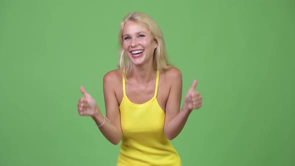 Young Happy Beautiful Blonde Woman Giving Thumbs Up While Looking Excited