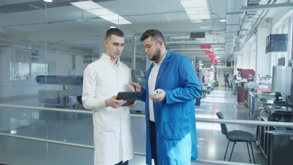 Industrial Employees with Tablet Inspecting Factory Equipment