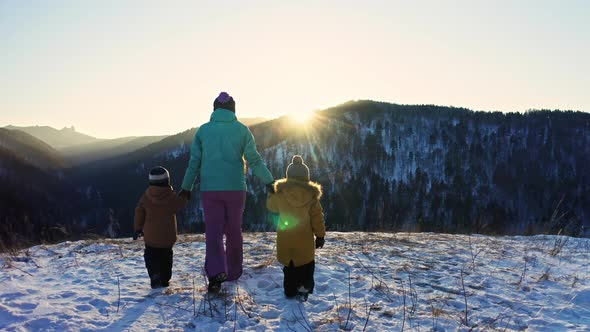 A Mother with Two Sons Goes to the Top of the Mountain at Sunset