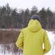 A man in a yellow jacket runs across a field covered with snow - VideoHive Item for Sale
