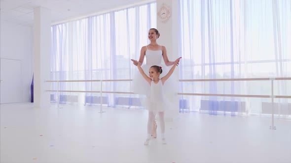 Ballet Teacher with Little Girl Training Steps on Tiptoe in Pointes Hold Hands