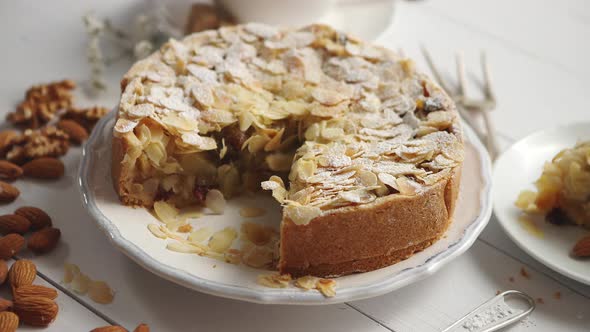 Whole Delicious Apple Cake with Almonds Served on Wooden Table alt