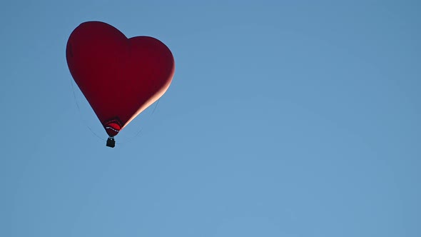 Colorful Hotair Heart Shape Balloon Flying on Sunset Over Blue Sky in Slow Motion Happy Valentines alt