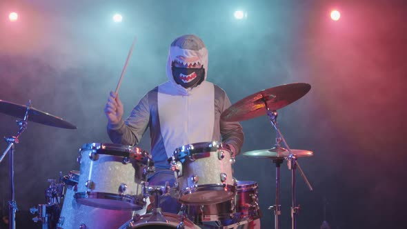 A Musician in a Festive Shark Costume Plays Drums and Hits Percussion Cymbals alt