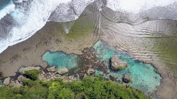 Aerial view of ocean waves at rock pool Magpupungko in Siargao, the Philippines. Camera flying down alt