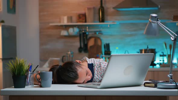 Overworked Woman Sleeping on Kitchen Desk alt