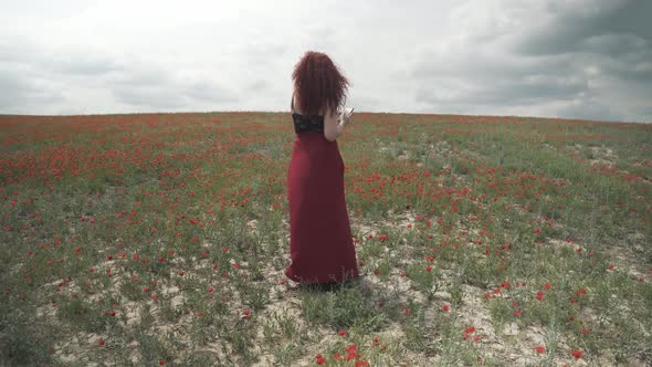 Girl with Mobile Phone in Poppy Field