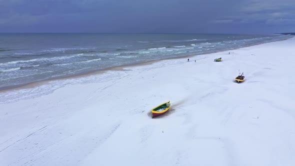 Ffishing boats on snowy beach, Baltic sea alt