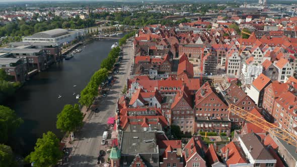Aerial Sliding Footage of Historic Brick Town Houses Wide Riverside Street and Trave River alt