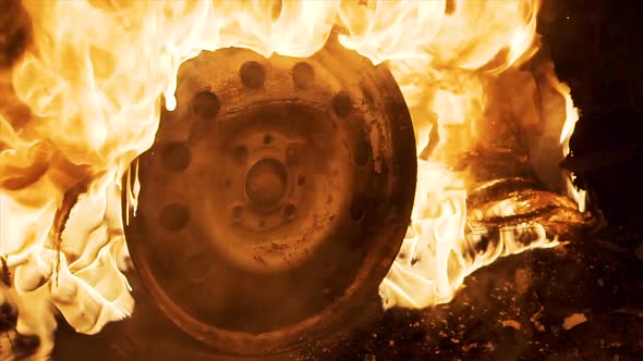 A wheel burns in a car at night, car tires burn
