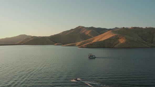 Aerial Drone Tracking Shot of a Boat and Several Jet Skis on a Lake (Lake Kaweah, Visalia, CA)