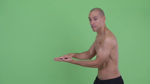 Happy Bald Multi Ethnic Shirtless Man Snapping Fingers and Showing Something alt