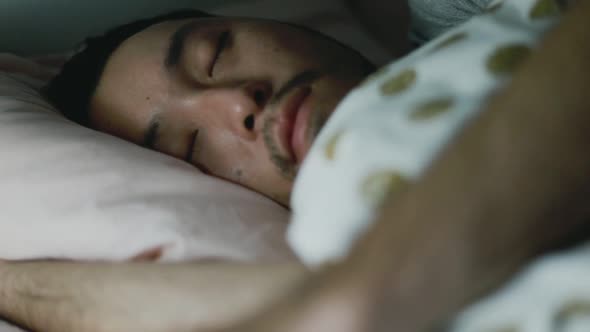 Close up of a young Asian man sleeping in the bedroom at home.