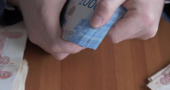 Male Hands Counting Money. Russian Money Banknotes of 2,000 Rubles