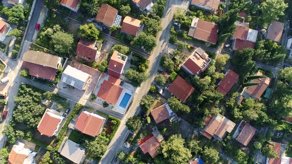 Flying Over Single Family Homes and Villas That Have Swimming Pools, Surrounded By Green Flora alt