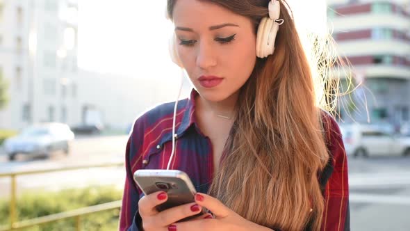 Young woman listening music smartphone dancing alt