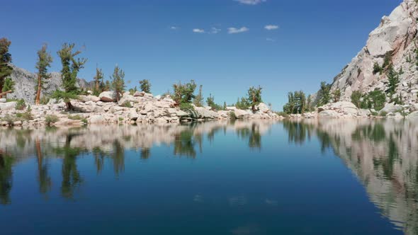 Cinematic Aerial of Blue Glacier Lake with Smooth Surface with Vivid Sky  USA alt