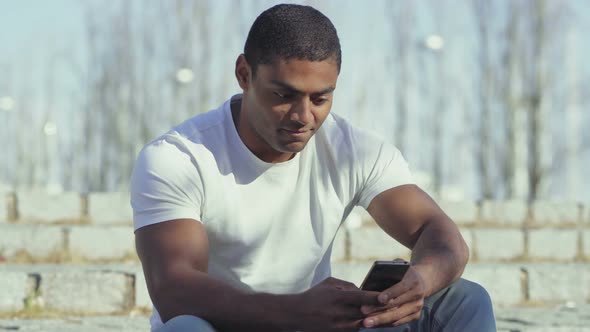 Smiling African American Man Holding Smartphone alt