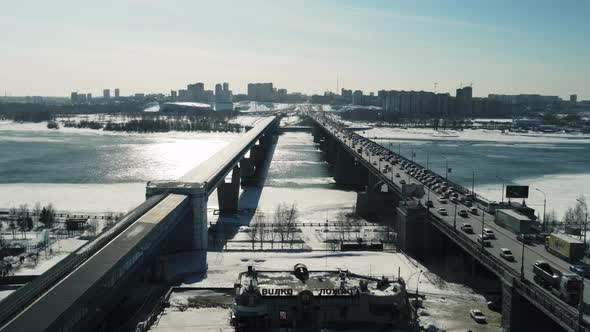 Two Bridges Connecting the Shore Against the Backdrop of the Counter Sun alt