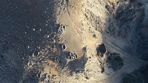 Top-down drone footage of tent in rocks circle on the summit of the Piton des Neiges at the Reunion alt