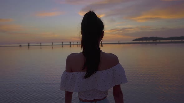 Pretty Asian Woman Walking Alone in the Sea at Beautiful Sunset Thailand alt