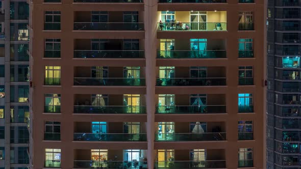 Glowing Windows in Multistory Modern Glass Residential Building Light Up at Night Timelapse alt