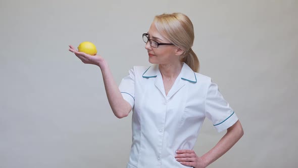 Nutritionist Doctor Healthy Lifestyle Concept - Holding Organic Lemon Fruit alt