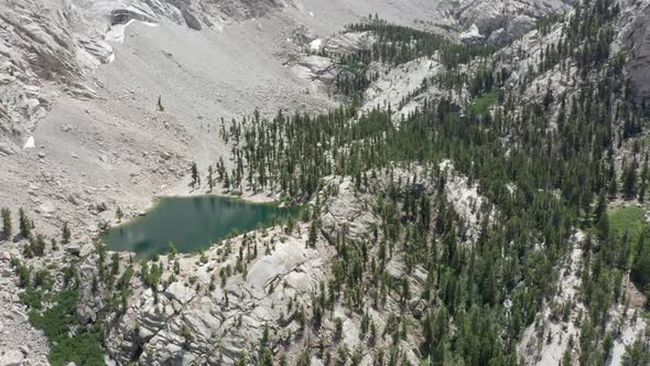 Cinematic Aerial Green Glacier Lake in Scenic Mountain Valley Pine Tree Forrest alt