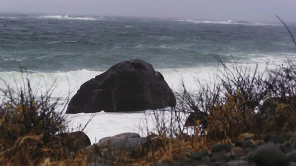 Waves Crashing On A Rock By The Coast Of Arendal In Norway On A Stormy Day - wide shot alt