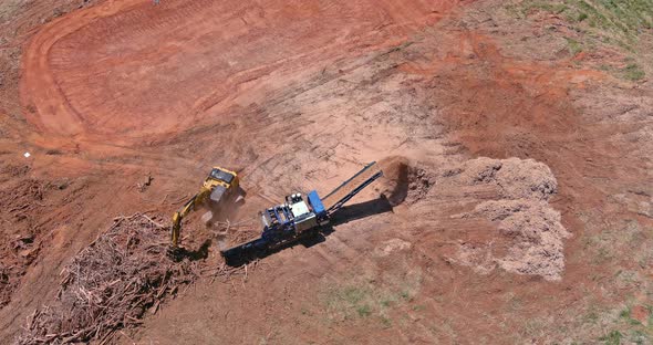 Work Conveyor of an Industrial Wood Shredder Producing Wood Chips From Roots in Construction Site alt