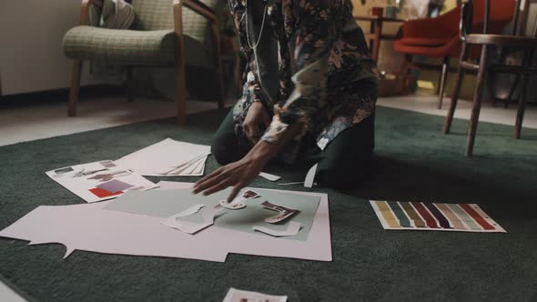 Male Fashion Designer Cutting out Paper Patterns in Workshop alt