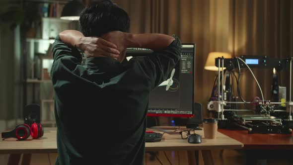 Back View Of Frustrated Asian Engineer Working On Personal Computer And 3D Printer alt