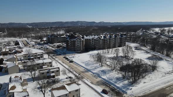 Aerial view of rural housing development of small homes and apartment buildings in winter.