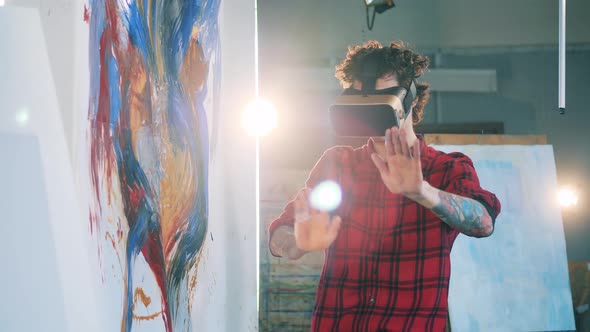 Young Man Is Wearing VRglasses in the Art Studio alt