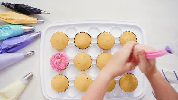 Step by step. Pastry chef piping butter cream frosting on unicorn cupcakes for little girl birthday  alt