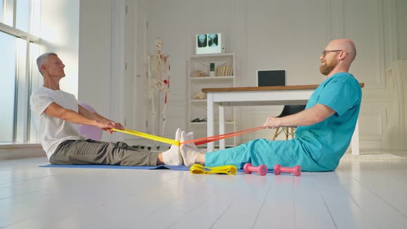A Physical Therapist Safely Trains a Patient Using Medical Exercise Equipment alt