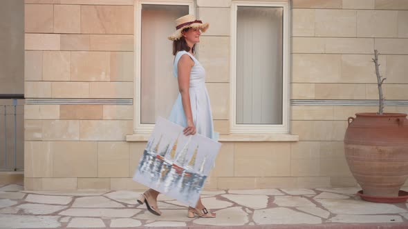 Side View of Happy Proud Woman Walking with Pictures in Slow Motion Smiling alt