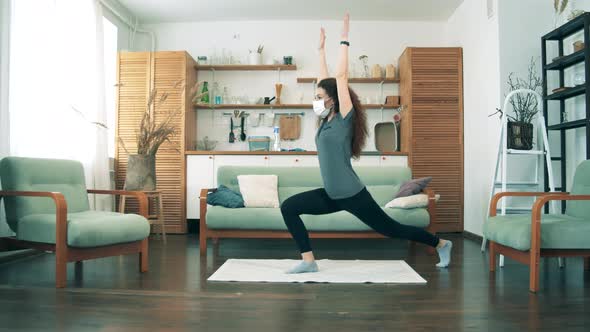 A Lady on Quarantine Is Doing Exercises at Home alt