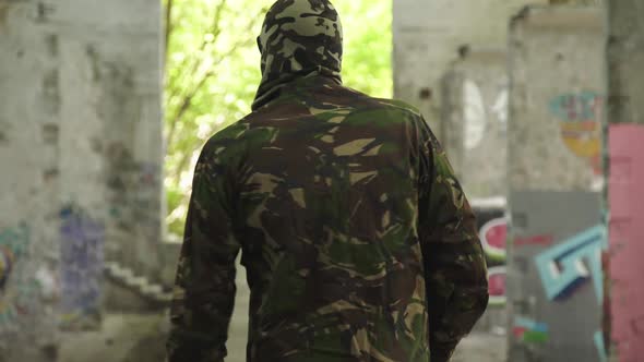 Back Look of Soldier in Uniform Walks in Ruins alt