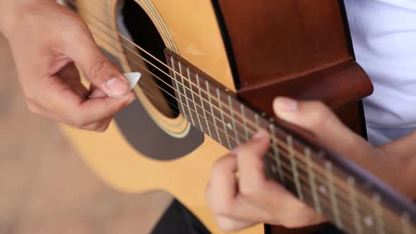 Close up of hand playing acoustic guitar
