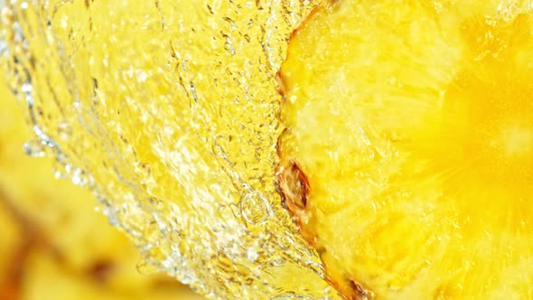 Super Slow Motion Shot of Splashing Water on Rotating Pineapple Slice at 1000Fps. alt