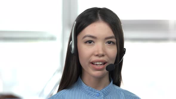 Caucasian Young Asian Girl Talking By Headset. alt