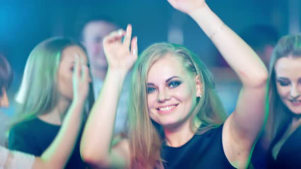 Beautiful Blond Woman is Dancing at a Party alt