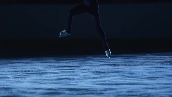 Figure Skating Lady is Skating on Ice Rink Training at Night in the Rays of Blue Light alt